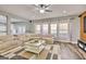Spacious living room featuring a large sectional sofa, modern ceiling fan, and bright natural light at 5845 Princeton Run Trl, Tucker, GA 30084