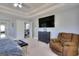 The main bedroom includes a TV, tray ceiling, and sitting area near the staircase at 5845 Princeton Run Trl, Tucker, GA 30084