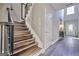 Inviting foyer showcasing staircase with wood treads, metal railing, and a soaring window for natural light at 5845 Princeton Run Trl, Tucker, GA 30084