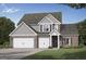 Two-story brick home with a two-car garage, gabled roof, and beautifully landscaped front yard at 782 Grande Bishop Dr, Fairburn, GA 30213