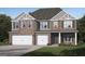 Charming two-story brick home with a two-car garage and manicured front lawn at 791 Grande Bishop Dr, Fairburn, GA 30213