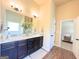 Bathroom features a dual sink vanity with granite counters, a large mirror, and wood look flooring at 104 Beautiful Way Lot 48 # 48, Locust Grove, GA 30248