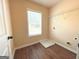 A bright laundry room with a large window, wood-look flooring, shelving, and washer and dryer hookups at 104 Beautiful Way Lot 48 # 48, Locust Grove, GA 30248