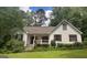 A lovely single-story home with manicured lawn, covered porch, and traditional architectural details at 128 Kelleytown Woods Dr, Mcdonough, GA 30252