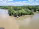 Expansive aerial view showcasing a tranquil lake with wooded shores and a charming boathouse at 2000 Campbell Rd, Covington, GA 30014
