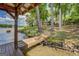 Exterior shot showcasing a home's lakeside dock and pathway, surrounded by towering trees and lush greenery at 2000 Campbell Rd, Covington, GA 30014