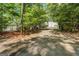 Long driveway leading to a lakeside home, bordered by lush trees and greenery for added privacy at 2000 Campbell Rd, Covington, GA 30014