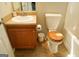 This bathroom has a traditional wooden vanity and toilet with wooden seat, complementing the neutral tiles at 65 Heaton Place Trl, Covington, GA 30016