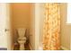Standard bathroom with a toilet, shower with curtain, and light beige colored walls at 65 Heaton Place Trl, Covington, GA 30016