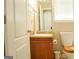 Cozy bathroom features a wooden vanity and framed mirror, plus a toilet with a wooden seat at 65 Heaton Place Trl, Covington, GA 30016