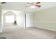 Spacious bedroom featuring a high vaulted ceiling, neutral carpet, a fan and a chair by the window at 65 Heaton Place Trl, Covington, GA 30016