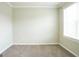 Empty bedroom with neutral carpet, freshly painted walls, and a bright window at 65 Heaton Place Trl, Covington, GA 30016