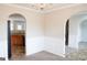 Empty dining room with carpet, wainscoting, and a view into the kitchen through an archway at 65 Heaton Place Trl, Covington, GA 30016