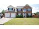 Charming two-story brick home with a well-manicured lawn and attached two-car garage at 65 Heaton Place Trl, Covington, GA 30016