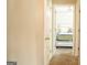Hallway leading to a carpeted bedroom with ceiling fan and white door at 65 Heaton Place Trl, Covington, GA 30016
