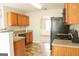 This kitchen features stainless steel appliances, wood cabinets, and stone countertops at 65 Heaton Place Trl, Covington, GA 30016