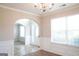 Bright, empty living room with neutral walls, carpet, wainscoting, and an arched doorway at 65 Heaton Place Trl, Covington, GA 30016
