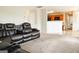 Spacious living room featuring plush carpeting and a large sectional sofa with reclining seats and cup holders at 65 Heaton Place Trl, Covington, GA 30016