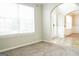 Bright, empty living room features neutral walls, carpet, and an arched doorway at 65 Heaton Place Trl, Covington, GA 30016