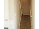 Carpeted staircase with white banister creates a welcoming and functional transition between floors at 65 Heaton Place Trl, Covington, GA 30016