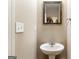 Neutral half-bathroom with a pedestal sink, round mirror, and a chrome towel ring at 447 W Wind Dr, Villa Rica, GA 30180