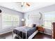 Serene bedroom with gray walls, tray ceiling, a white metal bed frame, and natural light at 447 W Wind Dr, Villa Rica, GA 30180