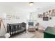 Bright Bedroom with a crib, chair, and decorative wall art at 447 W Wind Dr, Villa Rica, GA 30180