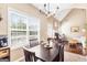 Cozy dining area with dark wood table, chandelier lighting, and a view to the living room and backyard at 447 W Wind Dr, Villa Rica, GA 30180