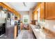 Functional kitchen with oak cabinets, black appliances, and a double sink beneath a window at 447 W Wind Dr, Villa Rica, GA 30180