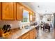 Bright kitchen featuring oak cabinets, a stainless steel dishwasher, and a view into the adjacent dining area at 447 W Wind Dr, Villa Rica, GA 30180