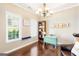 Bright office with a turquoise desk, bookshelf, and two windows providing natural light at 447 W Wind Dr, Villa Rica, GA 30180