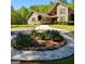 Landscaped front yard with a circular flower bed filled with vibrant purple flowers at 1685 Bailey Creek Sw Rd, Conyers, GA 30094