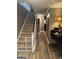 Hallway with carpeted stairs and hardwood floors adjacent to piano at 1685 Bailey Creek Sw Rd, Conyers, GA 30094
