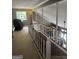 Hallway featuring wooden railing, carpeted floor and open view of living room below at 1685 Bailey Creek Sw Rd, Conyers, GA 30094