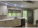 Kitchen has a sink under the window, quartz countertop, white cabinets, and a stainless-steel dishwasher at 1685 Bailey Creek Sw Rd, Conyers, GA 30094