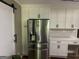 A stainless steel refrigerator is installed in the kitchen between white cabinets, drawers, and quartz countertops at 1685 Bailey Creek Sw Rd, Conyers, GA 30094