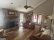 Living room with stone fireplace, ceiling fan, laminate floors, and outdoor access at 1685 Bailey Creek Sw Rd, Conyers, GA 30094