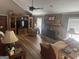 Living room with stone fireplace, ceiling fan, laminate floors, and entertainment center at 1685 Bailey Creek Sw Rd, Conyers, GA 30094
