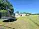 A large backyard with a trampoline, a fenced perimeter, a deck, and a partial view of the house at 140 Whitehead Sw Rd, Oxford, GA 30054