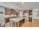 Modern kitchen with a granite-topped island with seating, stainless steel appliances, and dark wood cabinets at 228 Madison Grace Ave, Mcdonough, GA 30252