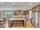 Spacious kitchen featuring granite countertops, dark wood cabinetry, a center island, and modern appliances at 228 Madison Grace Ave, Mcdonough, GA 30252