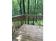 This deck has wood floors, a railing, and an overview of the wooded yard at 260 Pinehurst Dr, Stockbridge, GA 30281