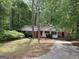Single-story home with red doors, lush greenery, and a driveway leading to a covered entrance at 260 Pinehurst Dr, Stockbridge, GA 30281