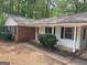 Single-story home featuring brick accents, a covered entryway and lush landscaping at 260 Pinehurst Dr, Stockbridge, GA 30281