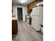 A kitchen featuring wooden cabinets, a white refrigerator, and modern laminate flooring at 260 Pinehurst Dr, Stockbridge, GA 30281