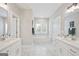 Elegant bathroom with double vanities, a soaking tub under a window, and marble countertops for a spa-like retreat at 61 Main St, Moreland, GA 30259