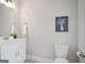 Bright bathroom featuring a white vanity, decorative star tile floor, and a floral print above the toilet at 61 Main St, Moreland, GA 30259