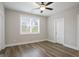 Inviting bedroom showcasing wood-look flooring, a bright window, and a modern ceiling fan at 61 Main St, Moreland, GA 30259