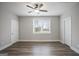 Spacious bedroom featuring neutral walls, hardwood flooring, a ceiling fan, and generous natural light at 61 Main St, Moreland, GA 30259