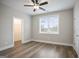 Bright bedroom featuring wood-look flooring, ceiling fan, walk-in closet, and natural light from a window at 61 Main St, Moreland, GA 30259